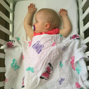 baby asleep with butterfly swaddle on top