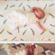 crib sheet with baby arms out asleep