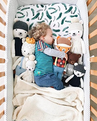 green feather crib sheet with toys 