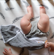 baby legs on top of fitted crib sheet 